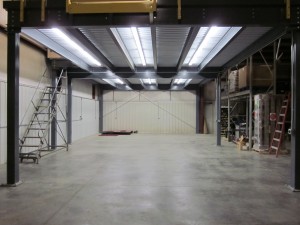 Underside of beam and c-section mezzanine with surface mounted lighting attached to the roof deck
